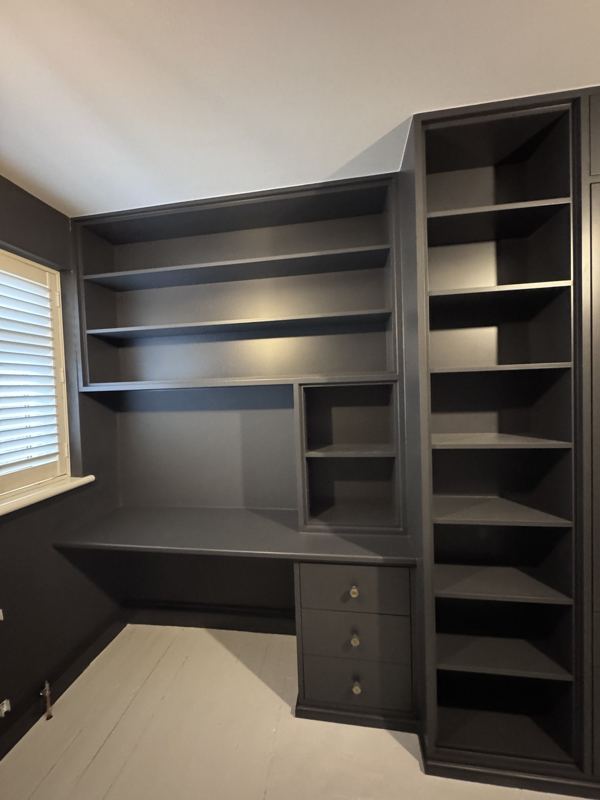 Built-in desk in the alcove by the window with shelves and drawers