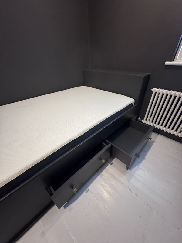 Fitted bed with its storage drawers pulled out