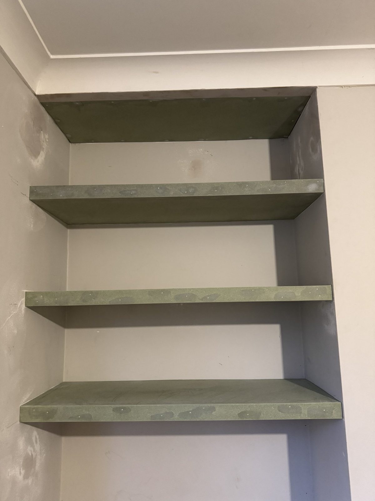 Three floating shelves built into an alcove, prepped ready for painting