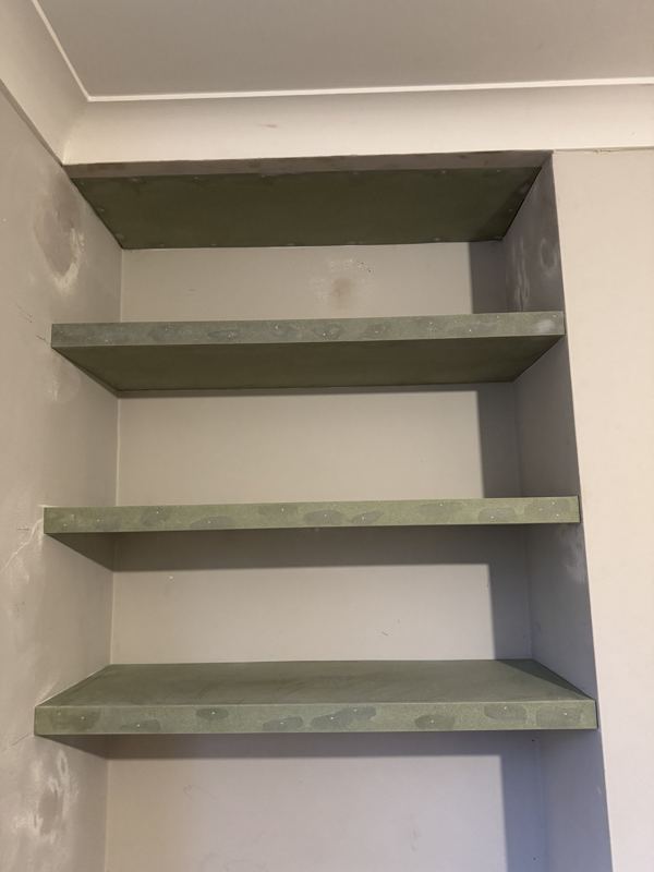 Three floating shelves built into an alcove, prepped ready for painting