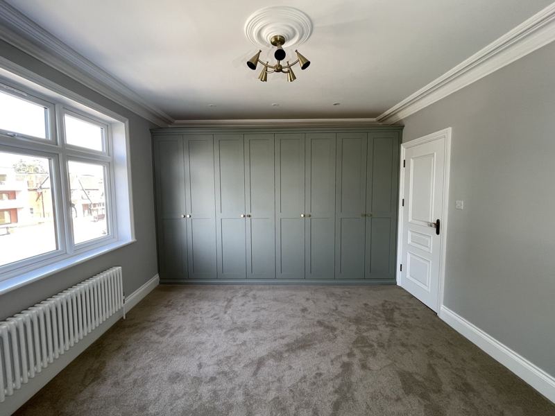 Bedroom with a full wall of fitted wardrobes running from wall to wall