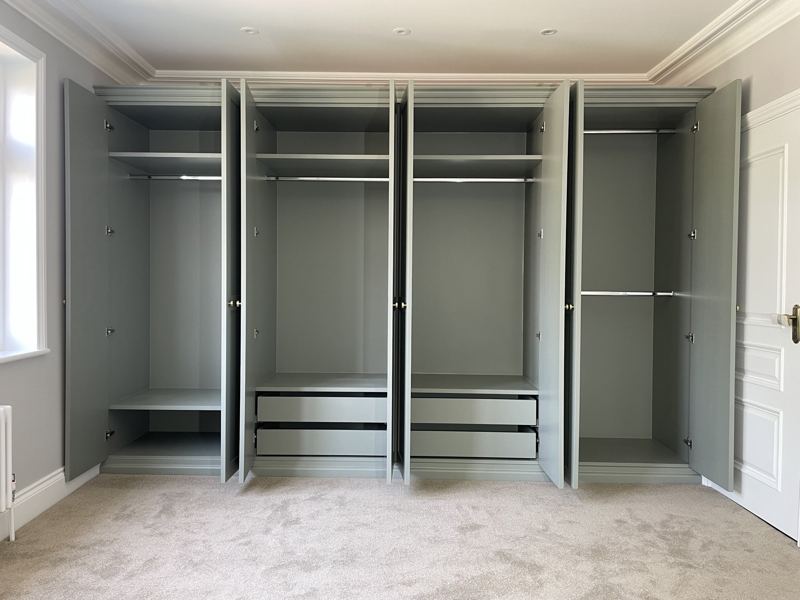 Fitted wardrobes with all doors open, showing shelves, hanging rails and drawers