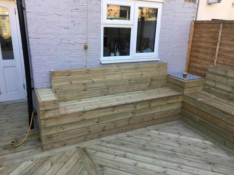 Finished garden decking with an L-shaped built-in bench