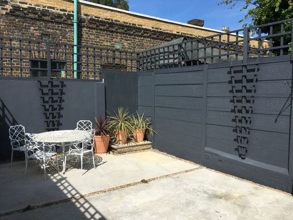 Courtyard garden with dark grey painted walls and new trellis