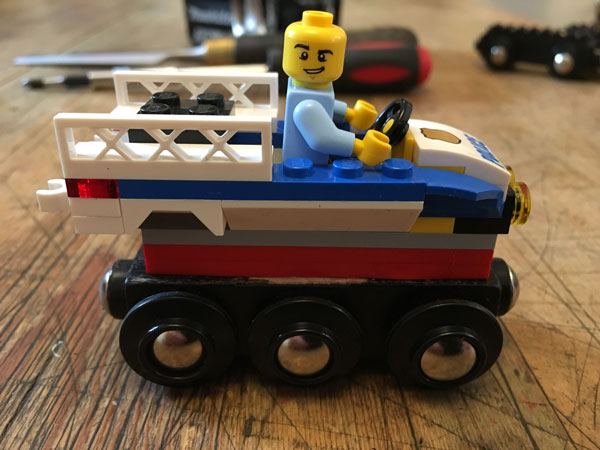 Lego police car mounted on a wooden train base
