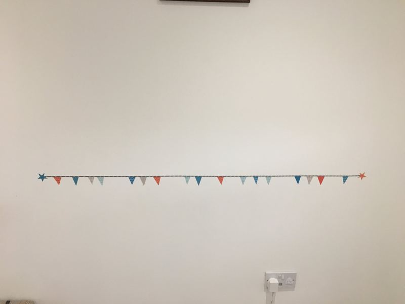 Bunting line going up first on a blank wall