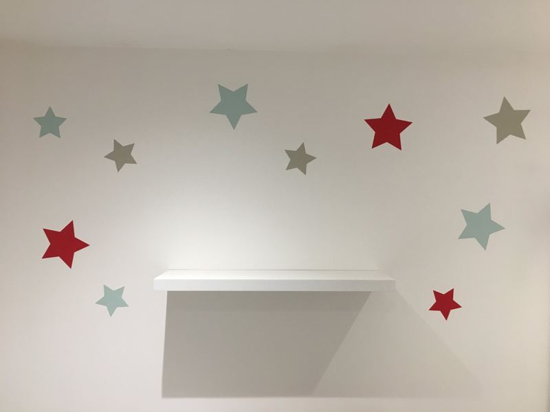 Stars scattered on the wall above a shelf
