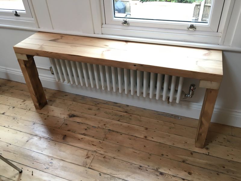 Chunky timber bench built over a radiator under a window