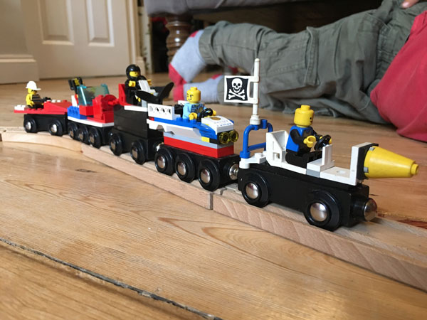 Child playing with Lego wooden trains